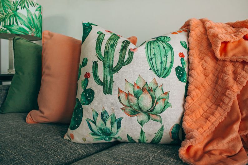 Home Decor Styles - three green, orange, and white throw pillows on sofa